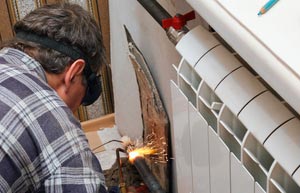 Engineer doing a welding job in heating pipes